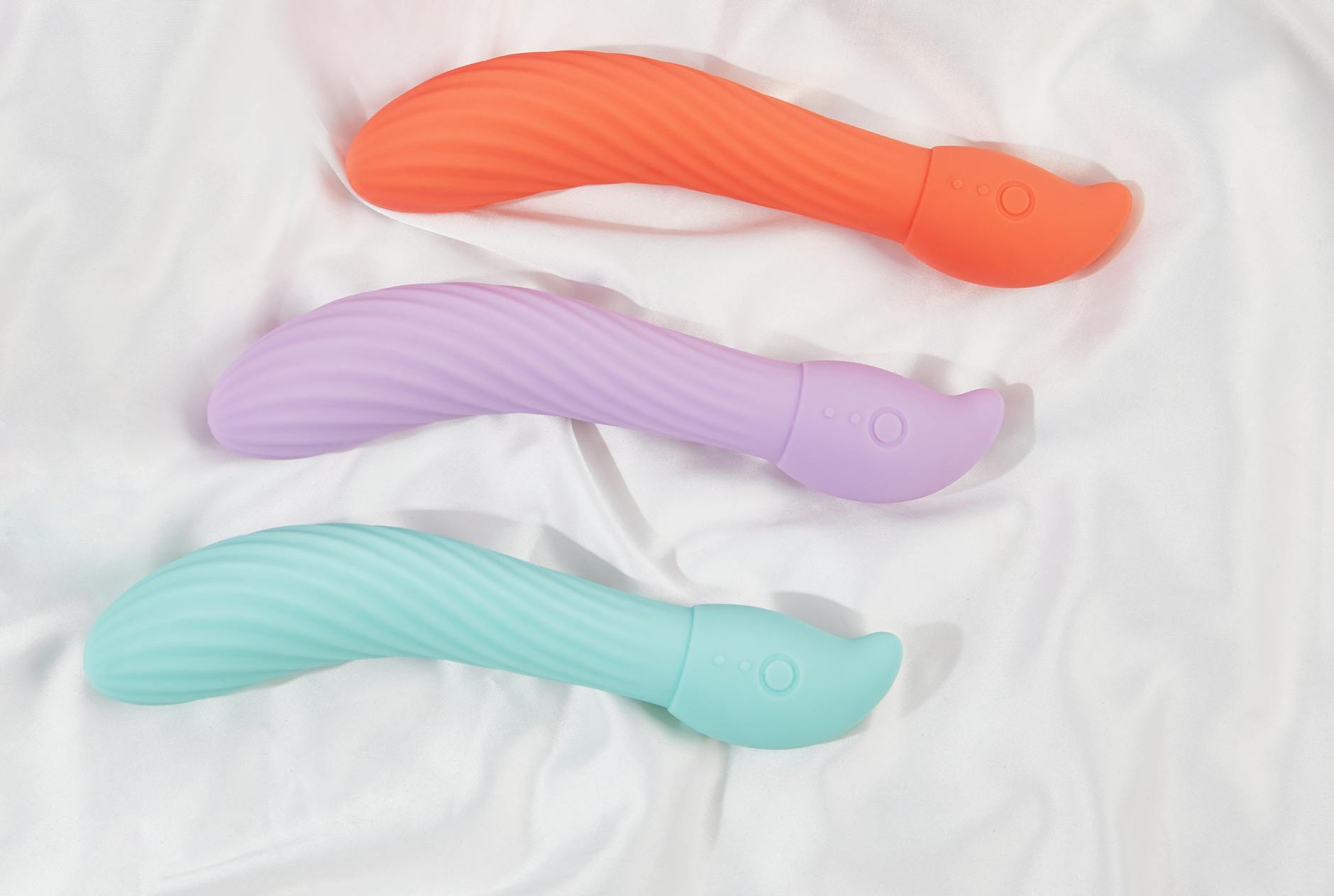Pink vibrator on a purple background with heart confetti and candles for a romantic vibe