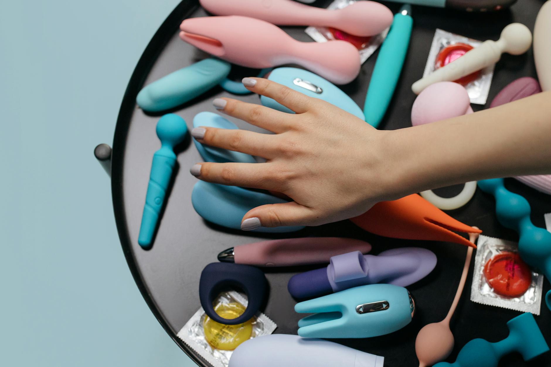 A blue silicone clitoral vibrator held in hand, symbolizing sexual wellness and pleasure recovery.