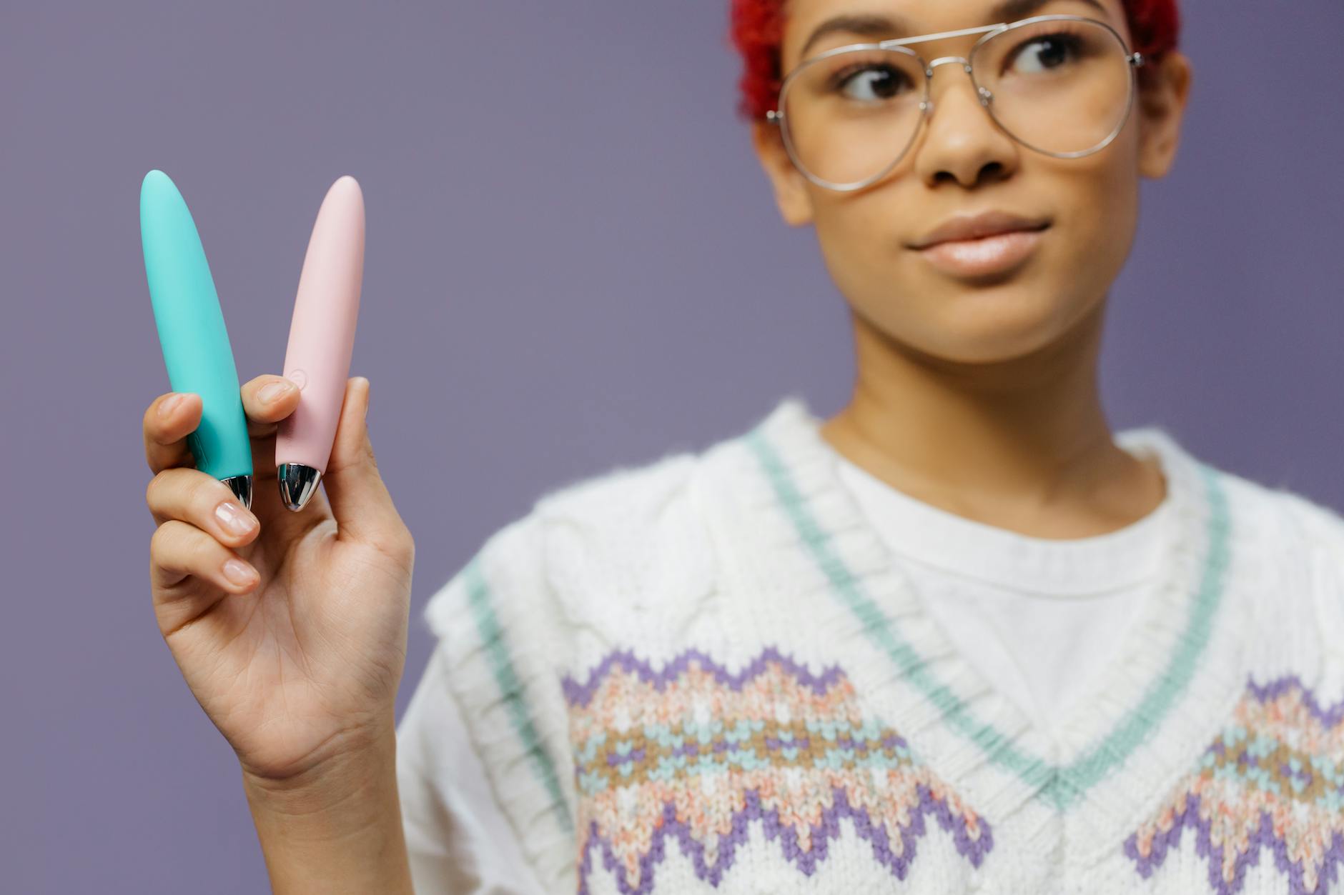 A young couple standing together indoors, holding a blue vibrator, symbolizing modern intimacy.
